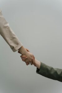 A close-up view of two people shaking hands, symbolizing cooperation and unity, with neutral-toned sleeves.